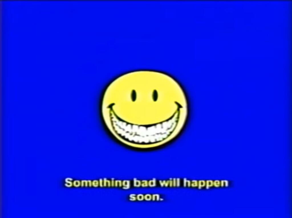 Желтая улыбающаяся рожица на синем фоне с текстом Something bad will happen soon, что означает «скоро случится что-то плохое