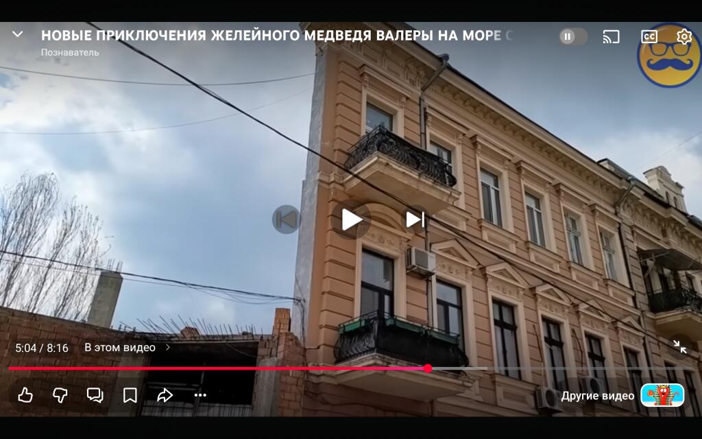 Скриншот видеоплеера с названием 'Новые приключения Желейного медведя Валеры на море' и изображением многоэтажного дома