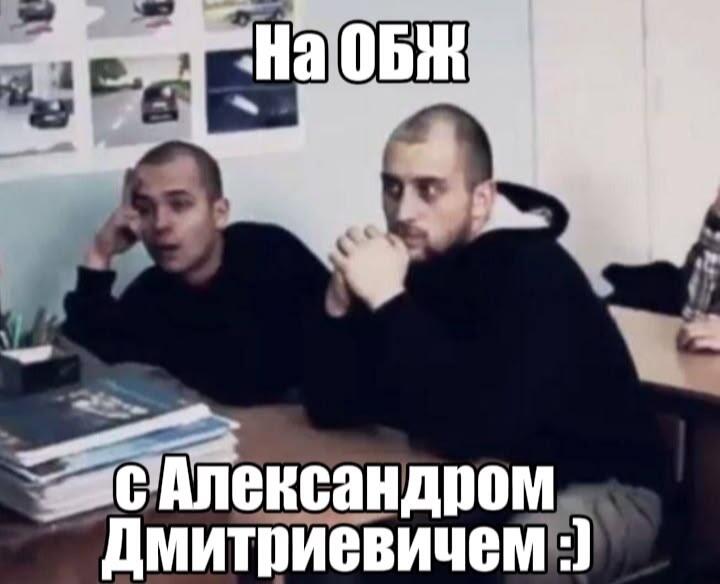 Два молодых человека с серьезными лицами сидят за партой, на стене фотографии машин, надпись «На ОБЖ с Александром Дмитриевичем :)